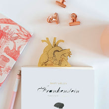 Cargar imagen en el visor de la galería, Marcapáginas de latón con forma anatómica de corazón metida en el libro de Mary Shelley Frankenstein