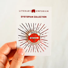 Cargar imagen en el visor de la galería, Pin esmaltado en color rojo y blaco con la inscripción Nolite Te Bastardes Carborundorum presentado en tarjeta de Dystopian Collection